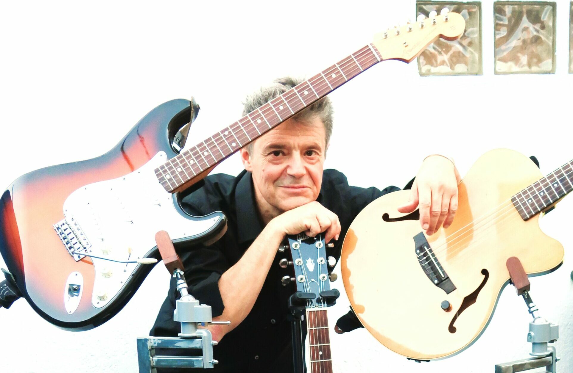 Olivier Delfor et ses guitares. Olivier Delfor avec ses guitares, pose sourire.